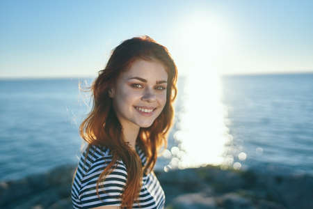 happy woman t-shirt at sunset near the sea in the mountains