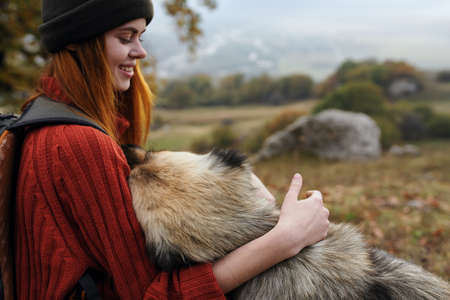 cheerful woman tourist playing with dog nature fresh air
