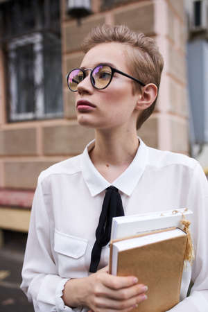 female student with books near building outdoors education science modelの写真素材