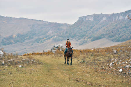 woman hiker in the mountains riding a horse adventure lifestyleの写真素材