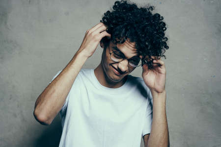 man with curly hair wearing glasses emotions white t-shirt studioの写真素材