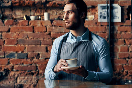 male waiter wearing apron coffee cup service lifestyleの写真素材