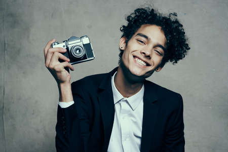 guy holding a camera in his hand retro classic suit curly model manの写真素材