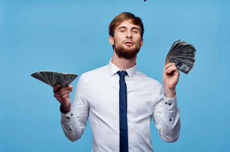 business man in shirt with tie wads of money finance blue backgroundの写真素材