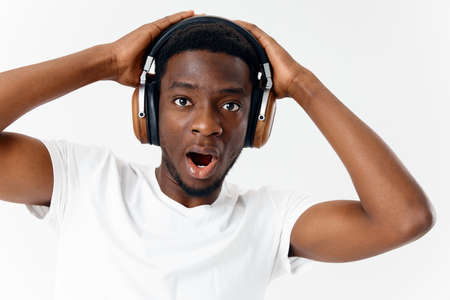 man with surprised facial expression in headphones listening to music emotions close upの写真素材