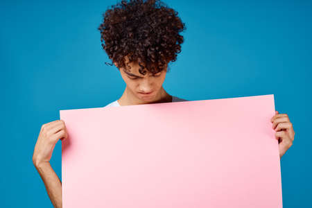 guy with curly hair holding pink Poster mockupの写真素材