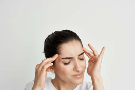 brunette holding her head health problems headache emotions treatment