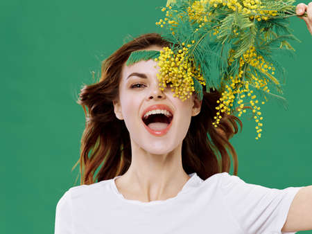 cheerful woman with a bouquet of flowers spring holiday womens day mimosaの写真素材