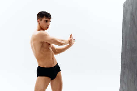 sexy male bodybuilder with a muscled body in dark panties posingの写真素材