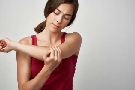 woman in red t shirt joint pain dissatisfaction health problemsの写真素材