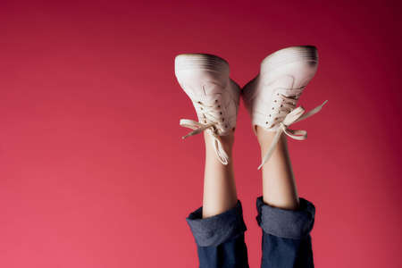 inverted female legs in white sneakers modern style isolated backgroundの写真素材