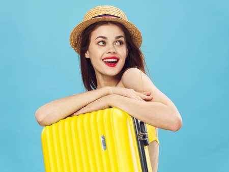 cheerful woman yellow suitcase vacation travel tripの写真素材