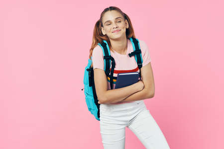 cheerful schoolgirl with backpack education knowledge pink background