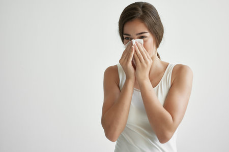woman blowing her nose in a handkerchief flu virus health problemsの写真素材