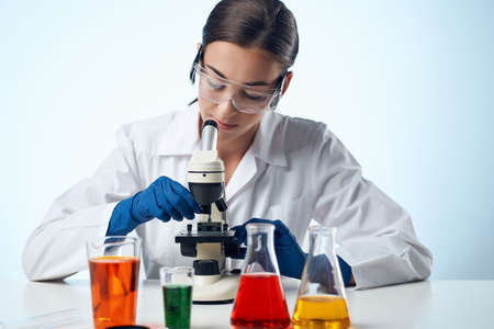 laboratory assistant in a white coat work table microscope diagnostics biotechnology