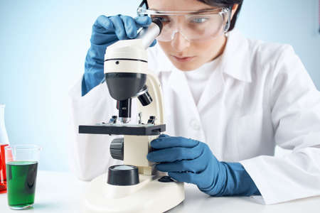 female laboratory assistant in medical gloves microscope biotechnology medicine