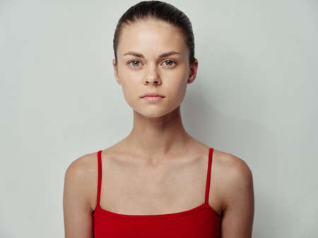 young woman clean skin cosmetology red t-shirt light background modelの写真素材