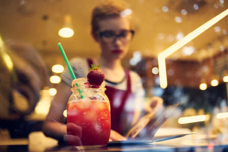 woman with short hair sits in a cafe with a cocktail relaxing enjoymentの写真素材
