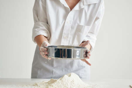woman baker sift flour cooking meal pastryの写真素材