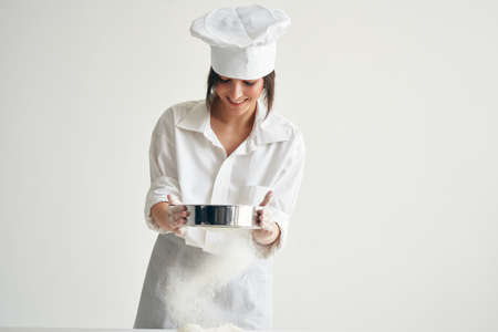 woman baker in chefs clothes professional working with dough kitchenの写真素材
