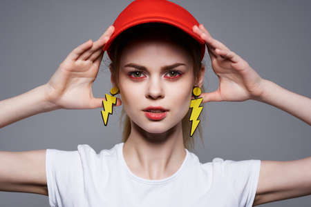 cheerful girl in a red cap yellow earrings makeup glamorの写真素材