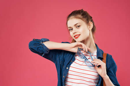 pretty young woman in fashion clothes backpack student posing pink backgroundの写真素材