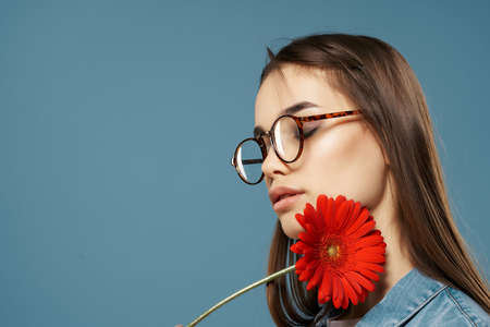 girl with a flower near her face glasses glamor close-upの写真素材