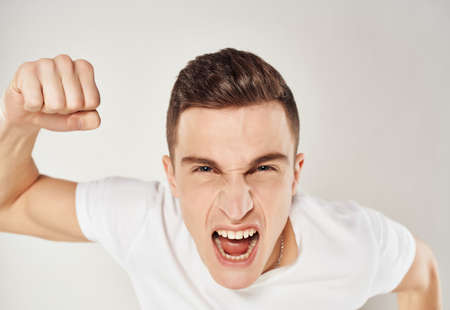 mad man in white t-shirt emotion light backgroundの写真素材