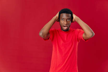 man of african appearance in red t-shirt isolated background emotions