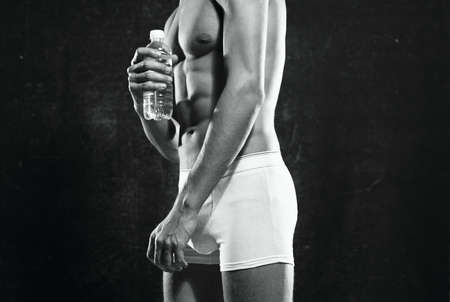 athletic men in white shorts pumped up press posing fitness dark background