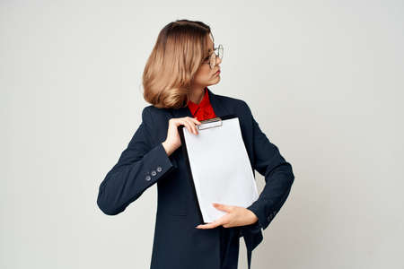 emotional business woman in suit folder with papers manager office light background