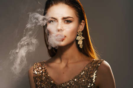 woman golden dress smoke from the mouth decoration luxury