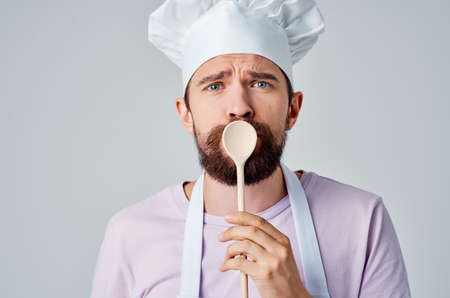 Cheerful chef with a spoon in his hands cooking food kitchen restaurant industryの写真素材