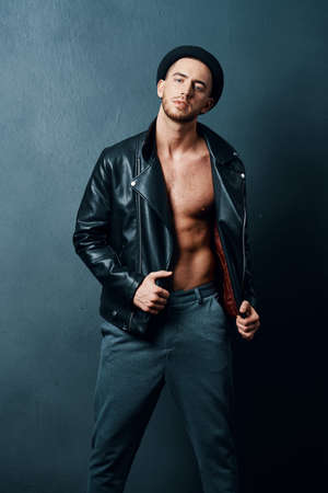 handsome man wearing hat leather jacket fashion modern posing styleの写真素材