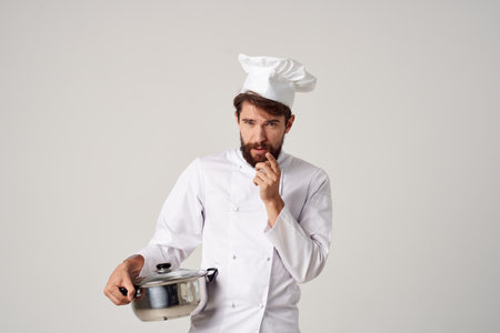 male chef with a saucepan in his hands cooking food service workの写真素材