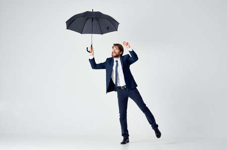 man in suit with umbrella emotions protection from rainの写真素材