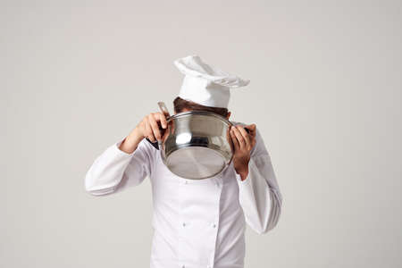 a man in a cooks uniform with a pan in his hands cooking service workの写真素材