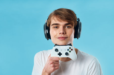 Guy in headphones in a white t-shirt joystick entertainment game consoleの写真素材