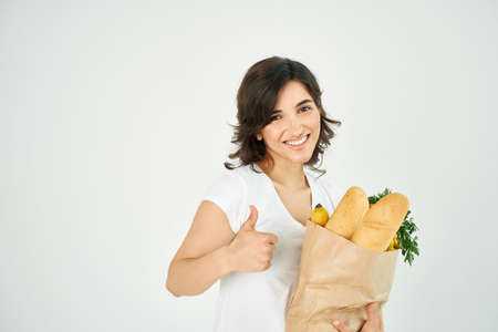 cheerful woman positive same string package with groceries in supermarket deliveryの写真素材