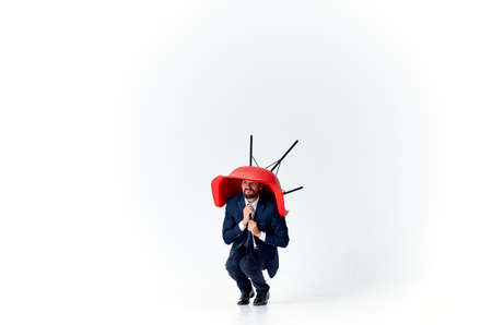 business man in a suit with a red chair in his hands above his head emotions