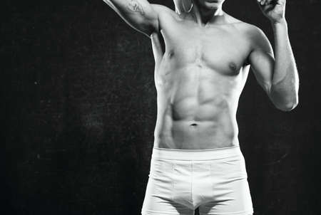 athletic men in white shorts pumped up press posing fitness dark backgroundの写真素材