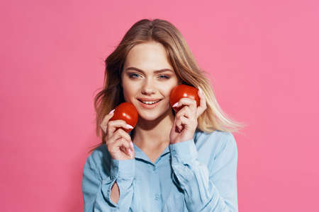 pretty woman in blue shirt with tomatoes in her hands foodの写真素材