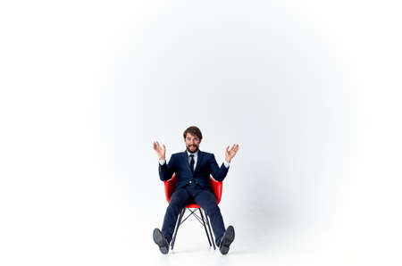 man in suit sitting on red chairs emotions office light backgroundの写真素材