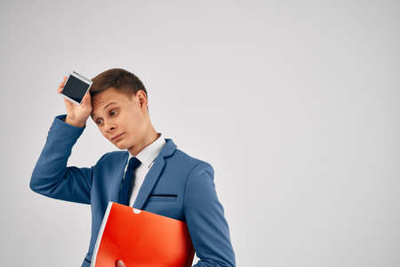 a man in a suit with a red folder a phone in his hands with communication technology