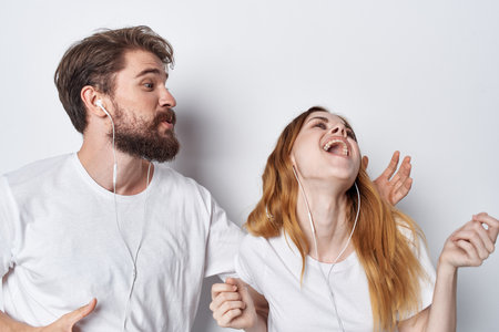 woman and man in white t-shirts are standing next to fun family studioの写真素材