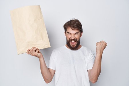 emotional man in a white t-shirt with a paper bag in his hands mocap close-up