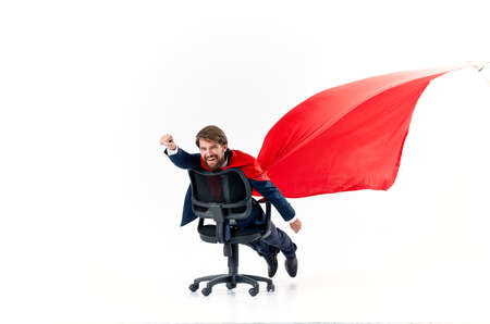 business man in a suit rides in a chair with a red cloak superhero manager