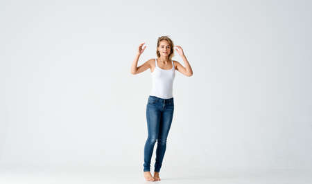 cheerful woman woman in jeans barefoot dancing on the floorの写真素材