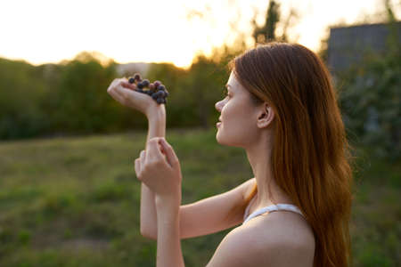 pretty woman with bunch of grapes nature fresh air