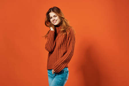 cheerful pretty woman in red sweater posing Studioの写真素材
